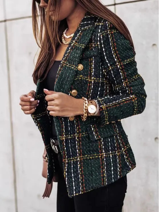 Person wearing a green plaid jacket with gold buttons against a light background